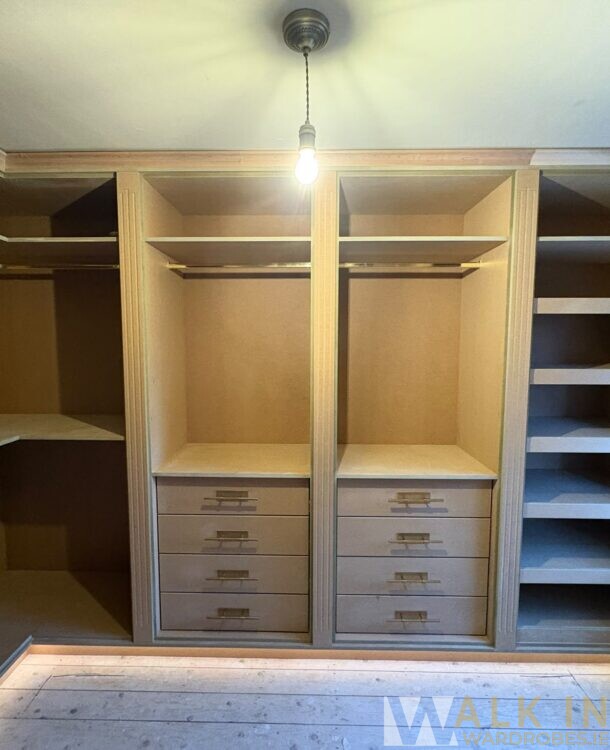 Spacious Walk-In Wardrobe With Wooden Shelves, Drawers, And Hanging Space In A Modern Room.